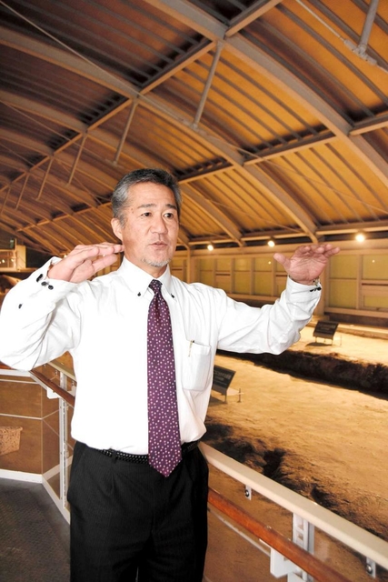 保存された野島断層の前に立つ震災語り部の米山正幸さん＝淡路市小倉