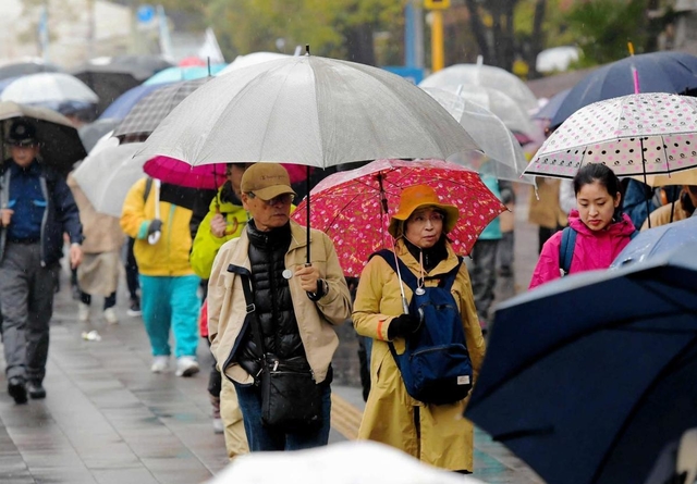 今年１月１７日のメモリアルウォークは雨の中、参加者が各地を巡った＝神戸市中央区