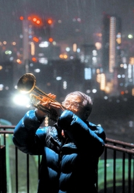 雨の中、神戸への思いを込めて演奏する、川崎市のトランペット奏者松平晃さん（７６）。「来られる限りは神戸に来て演奏したい」＝１７日午前６時２２分、神戸市中央区諏訪山町、ビーナスブリッジ（撮影・田中靖浩）