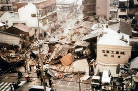 提供された震災直後の写真。多くの民家が倒壊し、被害の様子を伝える＝神戸市長田区（つどい実行委提供）