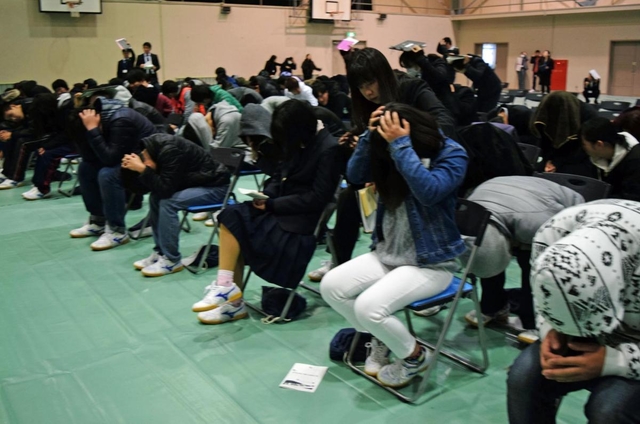 避難訓練で頭を手で覆い、身を守る生徒ら＝西脇北高校