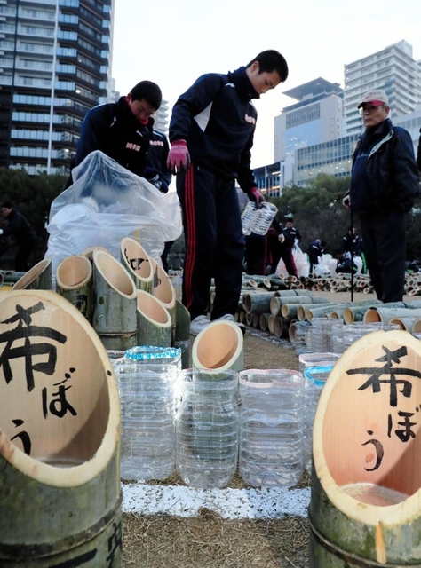 １・１７のつどい会場にペットボトルの灯籠を並べる高校生ボランティア＝１５日午後、神戸市中央区加納町６（撮影・大山伸一郎）