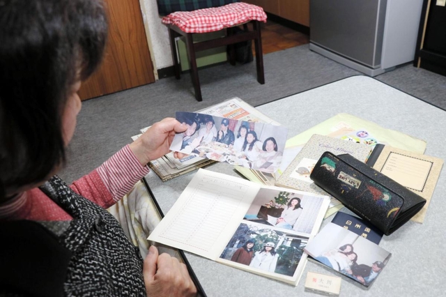 美幸さんの写真を眺める美佐代さん＝明石市