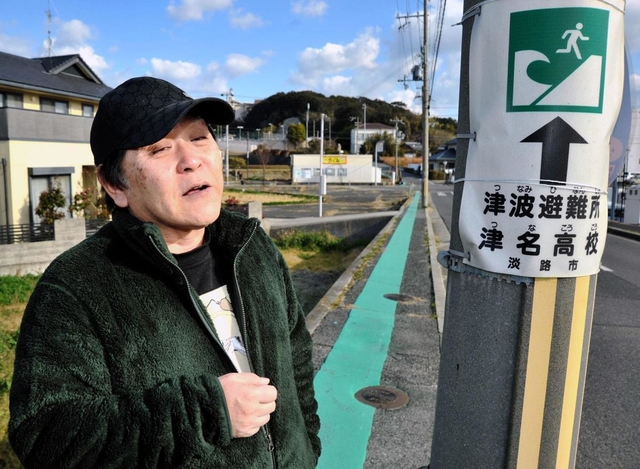 避難経路を示す緑色のラインに「見直しが必要」と訴える上野恵司さん＝淡路市志筑