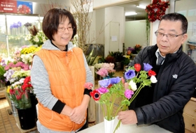 亡き母が好きだったというアネモネを手に思い出を振り返る西川昭彦さん（右）と恵子さん＝神戸市兵庫区神田町