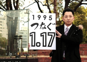 「１・１７のつどい」で描く文字を掲げる藤本真一実行委員長＝１１日午後、神戸市中央区、東遊園地