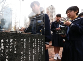「１・１７希望の灯り」からろうそくに火を移す生徒たち＝１２日午後、神戸市中央区加納町６、東遊園地（撮影・辰巳直之）