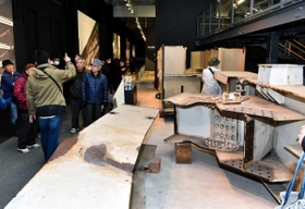 震災で損壊した部材の前で説明を聞く来館者ら＝神戸市東灘区深江浜町