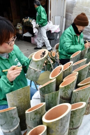 切りそろえた竹にメッセージを書き入れる神戸・心絆のメンバー＝三木市志染町広野