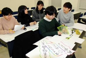 話し合いながら絵本づくりを進める学生たち＝神戸市中央区港島１
