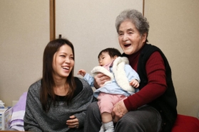 年末年始に帰省した三苫望美さん（左）と紗來ちゃんを笑顔で迎える野村佳さん＝西宮市甲子園浜田町（撮影・風斗雅博）