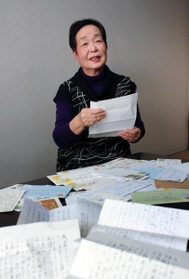 宮城県石巻市から届いた手紙を前に語る堀越明美さん＝神戸市垂水区北舞子２