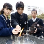 「１・１７希望の灯り」からろうそくに火を移す生徒たち＝１２日午後、神戸市中央区加納町６、東遊園地（撮影・辰巳直之）