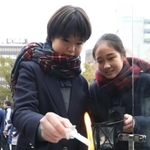 「１・１７希望の灯り」からろうそくに火を移す生徒たち＝１２日午後、神戸市中央区加納町６、東遊園地（撮影・辰巳直之）