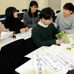話し合いながら絵本づくりを進める学生たち＝神戸市中央区港島１