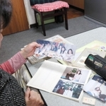 美幸さんの写真を眺める美佐代さん＝明石市