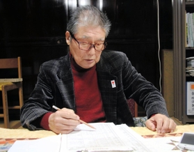 住民の名簿に目を通す神子畑区の山内隆次郎区長＝朝来市佐嚢