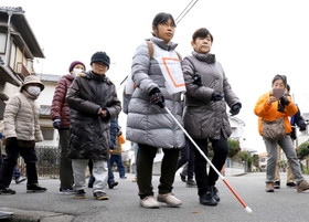 地域の避難訓練に参加した加藤恭子さん（中央）。「個別支援計画」に定めた支援者に付き添われて歩いた＝兵庫県播磨町北本荘１（撮影・大森　武）