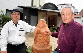 新潟県中越地震の被災地に５年ぶりに里帰りした地蔵を囲む曺弘利さん（左）と菅利秋さん＝神戸市長田区日吉町５