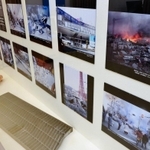 震災直後の神戸を撮影した写真パネルや、地震でゆがんだ側溝のふたなどが展示されている＝神戸市中央区下山手通４