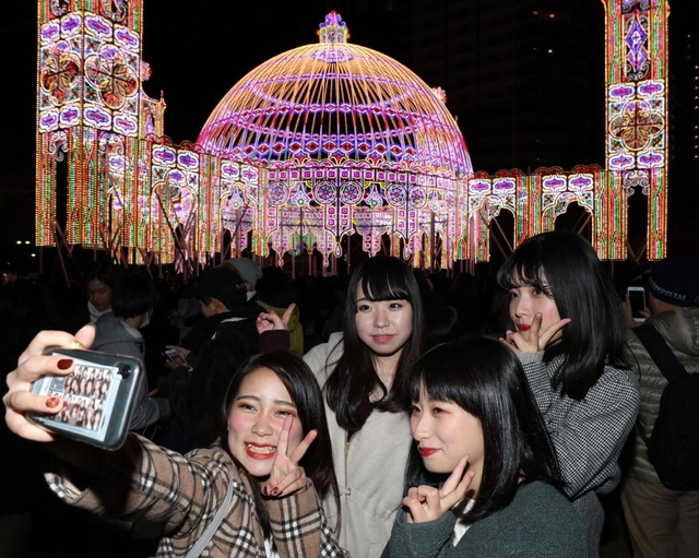 開幕初日に訪れ、写真撮影を楽しむ女性４人組＝６日夜、神戸市中央区加納町６（撮影・吉田敦史）