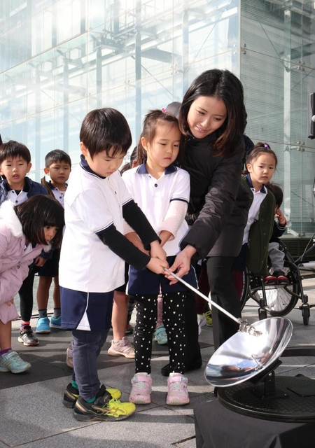太陽光を集める装置で採火を試みる園児ら＝９日午後、神戸市中央区脇浜海岸通１（撮影・辰巳直之）