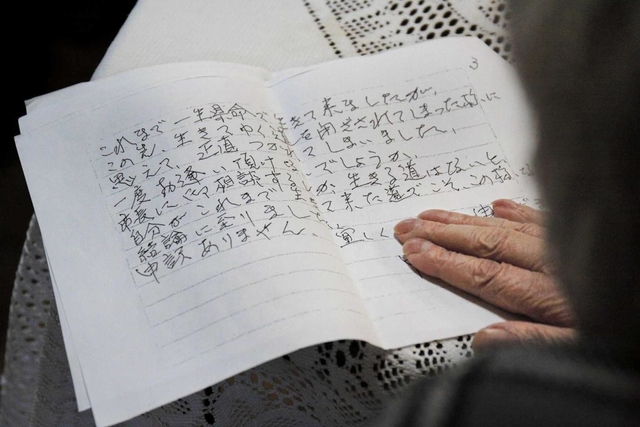神戸市長宛ての手紙の写しを手にする女性＝神戸市兵庫区