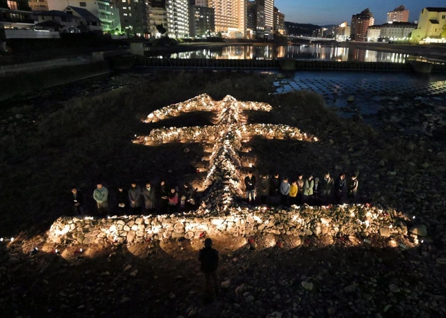 石を「生（せい）」の形に積んだオブジェがライトアップされた＝１６日午後５時４６分、宝塚市湯本町（写真・中西幸大）