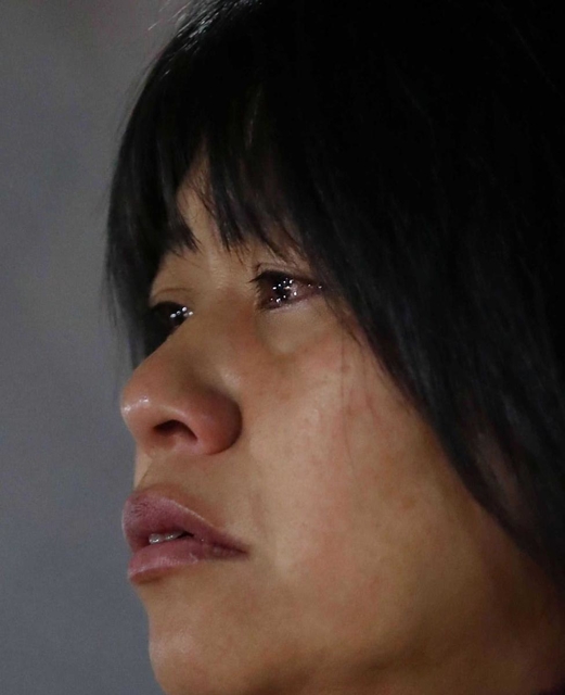 目に涙を浮かべ、慰霊碑を見つめる女性。思いがあふれる＝１７日午前６時２２分、神戸市長田区御蔵通５（撮影・大森　武）長田・御蔵北公園