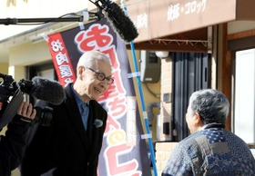 阪神・淡路大震災で被災した旧菅原市場跡を訪れ、取材する久米宏さん（左）＝神戸市長田区菅原通４（撮影・鈴木雅之）