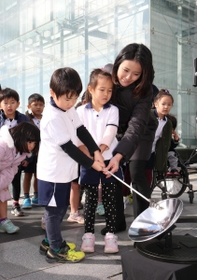 太陽光を集める装置で採火を試みる園児ら＝９日午後、神戸市中央区脇浜海岸通１（撮影・辰巳直之）