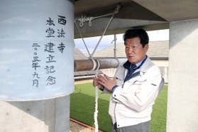 震災を語り継ごうとドラム缶の鐘を制作した藤野春樹さん＝芦屋市茶屋之町（撮影・風斗雅博）