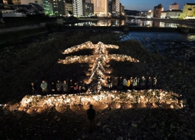 石を「生（せい）」の形に積んだオブジェがライトアップされた＝１６日午後５時４６分、宝塚市湯本町（写真・中西幸大）