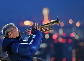 鎮魂の曲を奏でる松平晃さん＝１７日午前６時３０分、神戸市中央区、ビーナスブリッジ（撮影・中西幸大）