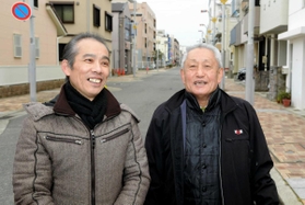 震災の火災で亡くなった林譲弥さんの救助活動以来、２５年ぶりに再会した長男幸弘さん（左）と菅利秋さん＝１７日午前８時２５分、神戸市長田区日吉町５（撮影・後藤亮平）