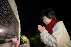 両親の名前が刻まれた碑の前で、手を合わせる原田美智子さん＝１７日午前６時３１分、西宮市奥畑（撮影・吉田敦史）