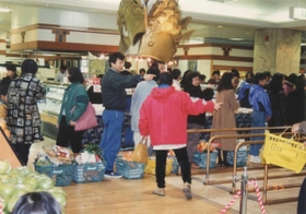 震災翌日、買い物かごに商品を山積みにし、並ぶ買い物客＝１９９５年１月１８日（同店提供）