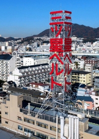 工場の屋上に立つ三ツ星ベルトの広告塔＝２０１７年１２月、神戸市長田区浜添通４（小型無人機で撮影）