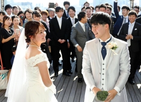家族らや友人から結婚の祝福を受ける岡本大二さん（手前右）と前田緑さん（同左）＝１３日午前、神戸市中央区北野町１（撮影・鈴木雅之）