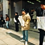 日銀神戸支店前で銀行名を書いた紙を持って、案内にあたる行員＝１９９５年１月２０日、神戸市中央区京町