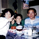 自宅でくつろぐ高田隼渡さん（中央）と父義文さん（右）、母キクヨさん＝神戸市中央区（１９９４年、隼渡さん提供））