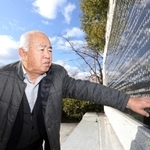 震災で亡くなった父国夫さんの名前を触る山本国輝さん＝西宮市奥畑、西宮震災記念碑公園（撮影・風斗雅博）