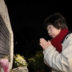 両親の名前が刻まれた碑の前で、手を合わせる原田美智子さん＝１７日午前６時３１分、西宮市奥畑（撮影・吉田敦史）