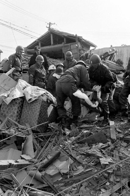 がれきの中から遺体を運び出す自衛隊員＝１９９５年１月１８日午前、神戸市長田区御船通