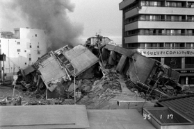 倒壊した７階建てのマンション。駅のホームに駆け上がりシャッターを切った＝１９９５年１月１７日午前７時台、西宮市のＪＲ甲子園口駅から撮影