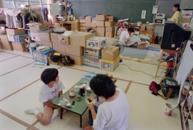 御影北小の避難所で配給の朝食を食べる人たち。避難所生活は長期化した＝１９９５年７月１９日