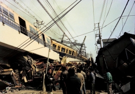 高架が崩れ、右に左に傾いた阪神電車の車両＝１７日午前、神戸市灘区大石東町３
