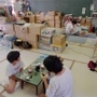 御影北小の避難所で配給の朝食を食べる人たち。避難所生活は長期化した＝１９９５年７月１９日