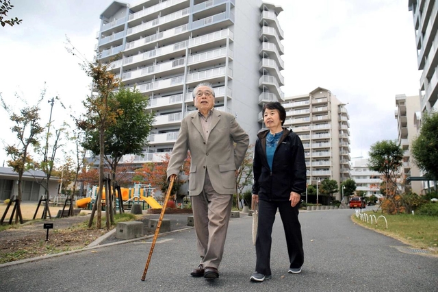 区画整理事業でなくなった甲陽市場を去り、ついのすみかとなった市営住宅の前を歩く畑野則雄さんと妻の千代乃さん＝芦屋市陽光町（撮影・風斗雅博）