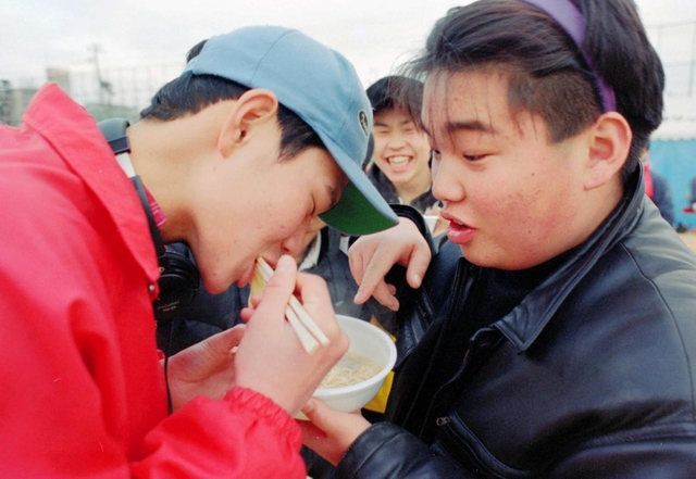 冗談を言い合いながら、炊き出しのラーメンを食べる。彼らの笑顔に救われた＝２１日午後、神戸市長田区、御蔵小学校